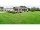 Beautifully landscaped front yard with lush green grass, mature plantings, and a charming single-story home at 17461 Se 82Nd Albemarle Ave, The Villages, FL 32162