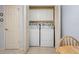 Washer and dryer in closet behind bi-fold doors, with storage and decorative wallpaper at 17461 Se 82Nd Albemarle Ave, The Villages, FL 32162