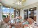 Enclosed lanai featuring wicker furniture with blue cushions and a glass-top table for relaxing indoor/outdoor living at 17461 Se 82Nd Albemarle Ave, The Villages, FL 32162