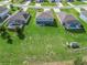 Aerial view of backyard featuring a beautiful green lawn, patio area, and adjacent screened-in pools at 1824 Forest Glen Dr, Fruitland Park, FL 34731