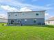 Exterior of home features a spacious backyard with a dining patio and a lush green lawn at 1824 Forest Glen Dr, Fruitland Park, FL 34731