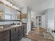Bathroom featuring a double sink vanity, framed mirror, and access to a walk-in closet at 1824 Forest Glen Dr, Fruitland Park, FL 34731