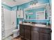 Cozy bathroom featuring dual sinks, a tub with a shower and ample storage space at 1824 Forest Glen Dr, Fruitland Park, FL 34731