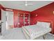 Bright bedroom showcasing red walls, neutral carpet and a built-in bookshelf, offering ample storage at 1824 Forest Glen Dr, Fruitland Park, FL 34731