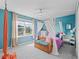 Cozy bedroom with a window and canopy bed with whimsical sheer curtains and a wood bench at 1824 Forest Glen Dr, Fruitland Park, FL 34731