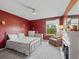 Cozy bedroom boasts a neutral carpet, red walls, a decorative fireplace and a comfortable chair at 1824 Forest Glen Dr, Fruitland Park, FL 34731