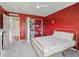 Bright bedroom showcasing red walls, neutral carpet and a closet, offering ample storage space at 1824 Forest Glen Dr, Fruitland Park, FL 34731