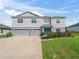 Charming two-story home with gray siding, well-kept lawn and bright blue front door at 1824 Forest Glen Dr, Fruitland Park, FL 34731