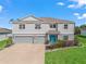 Charming two-story home with a well-manicured lawn, landscaped garden, and a welcoming blue front door at 1824 Forest Glen Dr, Fruitland Park, FL 34731