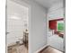 View of a hallway with two open doorways, one into a bathroom and the other into a bedroom at 1824 Forest Glen Dr, Fruitland Park, FL 34731