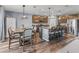 Spacious kitchen and dining area with hardwood floors, granite countertops, stainless steel appliances, and a kitchen island at 1824 Forest Glen Dr, Fruitland Park, FL 34731