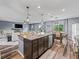 Open concept kitchen and living room with wood floors, a kitchen island with barstool seating, and stainless steel appliances at 1824 Forest Glen Dr, Fruitland Park, FL 34731