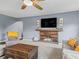 Cozy living room with gray walls, carpet flooring, a fireplace, and a ceiling fan at 1824 Forest Glen Dr, Fruitland Park, FL 34731