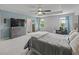 Main bedroom featuring a tray ceiling, large windows, a dresser, and a television at 1824 Forest Glen Dr, Fruitland Park, FL 34731