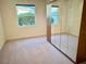 Bedroom featuring a large window and a closet with mirrored doors at 20936 Royal St Georges Ln, Leesburg, FL 34748