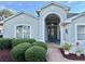 Charming home featuring an arched entryway, glass front door, and well-manicured shrubbery at 20936 Royal St Georges Ln, Leesburg, FL 34748