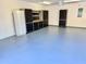 Light blue garage with storage cabinets and an open workspace at 20936 Royal St Georges Ln, Leesburg, FL 34748