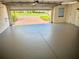 Spacious, light grey garage with an open door and brick paver driveway at 20936 Royal St Georges Ln, Leesburg, FL 34748