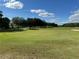 Scenic view of the lush green golf course on a bright, sunny day with a flag on the putting green at 20936 Royal St Georges Ln, Leesburg, FL 34748