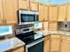 Well-lit kitchen showcasing stainless steel appliances and light wood cabinets at 20936 Royal St Georges Ln, Leesburg, FL 34748
