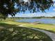 Beautiful Royal Highlands lake view with dock, grass, and tree shaded sidewalk at 20936 Royal St Georges Ln, Leesburg, FL 34748