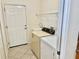 Bright laundry room featuring a utility sink, washer, dryer, and shelving at 20936 Royal St Georges Ln, Leesburg, FL 34748