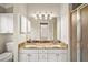 Bathroom featuring a large mirror over double sinks with granite countertops and white cabinets at 2104 Gerardo Ave, The Villages, FL 32159