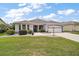 Charming one-story home with a well-manicured lawn, stone accents, and an attached two-car garage at 2104 Gerardo Ave, The Villages, FL 32159