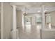 Bright living room featuring tile floors, large windows, decorative columns, and an elegant chandelier at 2104 Gerardo Ave, The Villages, FL 32159