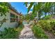 Tropical landscaped backyard with a beautiful pool, brick-paved walkway, and well-manicured lawn at 2214 Dogwood Cir, Mount Dora, FL 32757