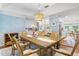 Open dining area leading to a living room, features a long table and hardwood floors at 2214 Dogwood Cir, Mount Dora, FL 32757