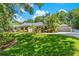 Spacious house with well-manicured lawn, colorful flower beds, and a detached garage at 2214 Dogwood Cir, Mount Dora, FL 32757