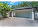 Detached garage with white paint, a large garage door, and side entry at 2214 Dogwood Cir, Mount Dora, FL 32757