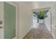 A hallway with white walls, a door with a glass pane, and a view of the yard and landscaping at 2214 Dogwood Cir, Mount Dora, FL 32757