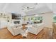 Bright living room featuring hardwood floors, a fireplace, built-in shelving, and access to the outdoor patio at 2214 Dogwood Cir, Mount Dora, FL 32757