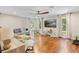 Spacious living room featuring hardwood floors, large windows and television at 2214 Dogwood Cir, Mount Dora, FL 32757