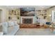 Inviting living room with a brick fireplace, built-in shelving, and a decorative beach themed picture above the fireplace at 2214 Dogwood Cir, Mount Dora, FL 32757