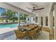 Outdoor patio with a table, dining chairs, and ceiling fan overlooking the pool at 2214 Dogwood Cir, Mount Dora, FL 32757