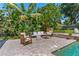 An outdoor living space that includes a pool, conversation seating, lush landscaping, and mature trees at 2214 Dogwood Cir, Mount Dora, FL 32757