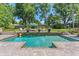Backyard pool features stone accents, patio furniture, and lush landscaping at 2214 Dogwood Cir, Mount Dora, FL 32757