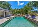 Backyard pool with beautiful landscaping, patio furniture, and blue skies above at 2214 Dogwood Cir, Mount Dora, FL 32757