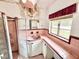 Bathroom with a sink, mirror, window, shower and pink and white tile at 2237 Washington Rd, Mount Dora, FL 32757