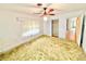 Bedroom with a ceiling fan, carpet, walk-in closet, and bright, natural light from the windows at 2237 Washington Rd, Mount Dora, FL 32757