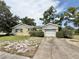 View of the home's facade, including a one-car garage, driveway, and mature landscaping at 2237 Washington Rd, Mount Dora, FL 32757