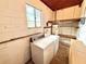 Laundry room with a washer, dryer, shelving, window and concrete walls at 2237 Washington Rd, Mount Dora, FL 32757