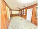Cozy living room features wood paneling, ceiling fan, and bright window letting in natural light at 2237 Washington Rd, Mount Dora, FL 32757