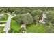 Aerial view of a landscaped home with mature trees on a large lot at 24 Brigadoon Cir, Leesburg, FL 34788