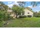 A view of the backyard with lush green lawn and shrubbery around the perimeter of the house at 24 Brigadoon Cir, Leesburg, FL 34788