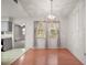 Dining room with hardwood floors, chandelier, and view into the kitchen area at 24 Brigadoon Cir, Leesburg, FL 34788