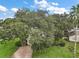 A view of a home and the front yard with mature trees at 24 Brigadoon Cir, Leesburg, FL 34788